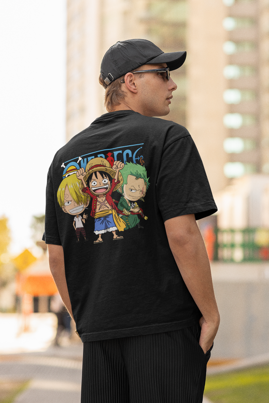 Back view of a male model wearing a black oversized t-shirt featuring chibi versions of the main characters from the One Piece anime.