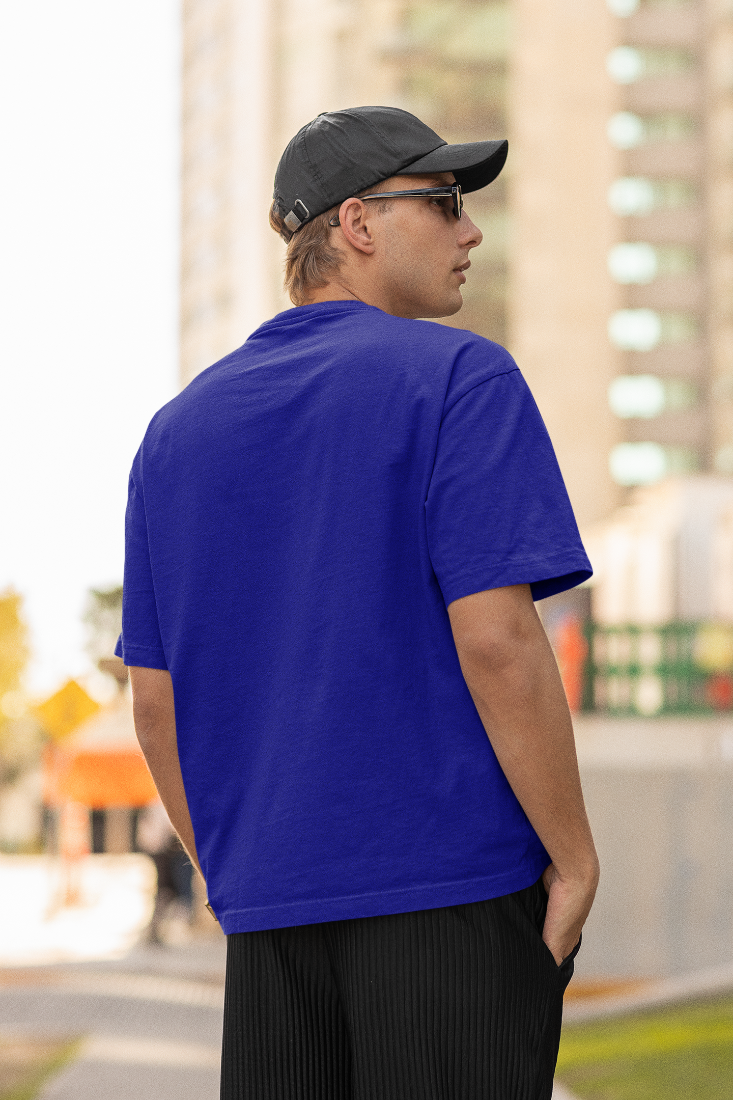 Back view of a male model wearing a royal blue oversized t-shirt featuring Tanjiro Kamado from Demon Slayer: Kimetsu no Yaiba.