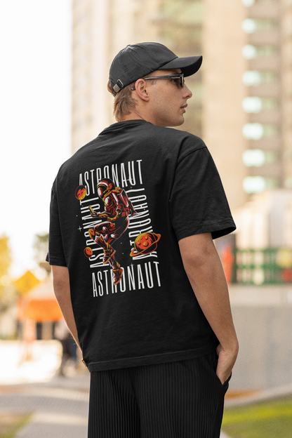 Back view of male model wearing a black oversized t-shirt featuring a captivating "celestial" design that incorporates subtle elements of the Milky Way galaxy, planets, and the wonders of space. Ideal for aspiring astronauts and space enthusiasts.