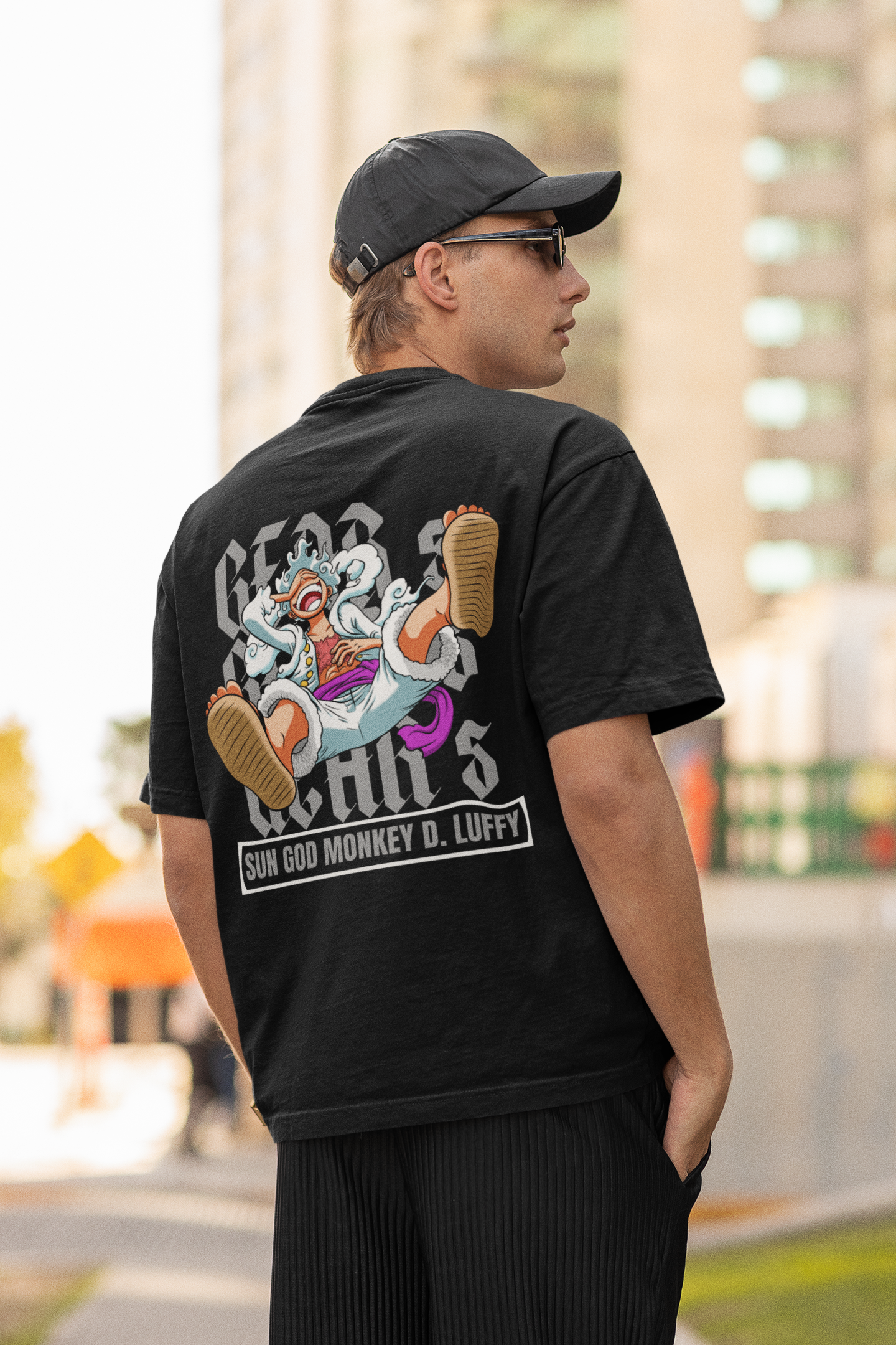 Back view of a male model wearing a black oversized t-shirt featuring Luffy in his Gear 5 form from the One Piece anime.