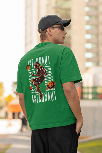 Back view of male model wearing a forest green oversized t-shirt featuring a captivating "celestial" design that incorporates subtle elements of the Milky Way galaxy, planets, and the wonders of space. Ideal for aspiring astronauts and space enthusiasts.