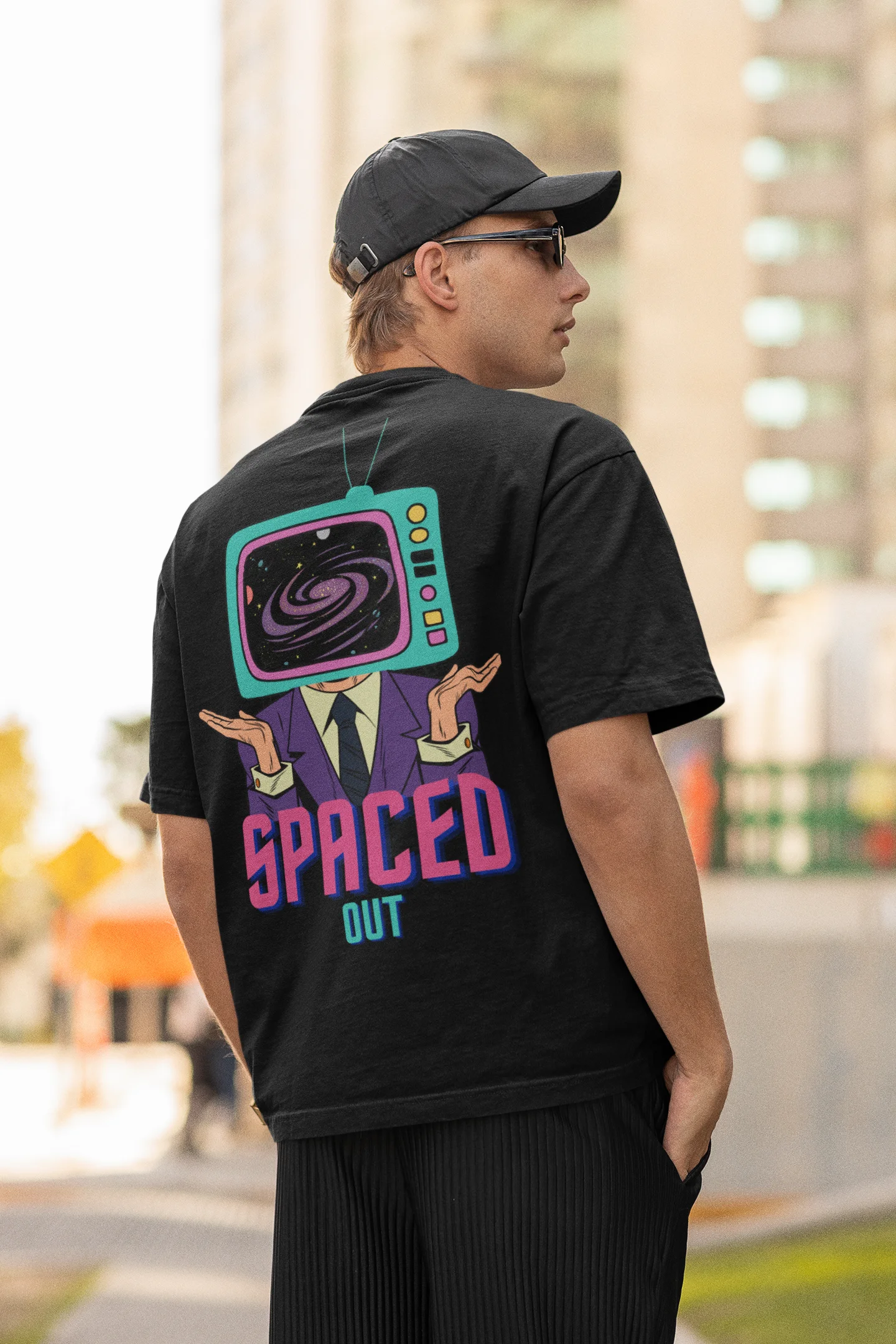 Back view of a male model wearing a black oversized t-shirt with a bold graphic that reads "Need Some Space" on the front. The design incorporates subtle hints of the Milky Way galaxy and the solar system on the back.