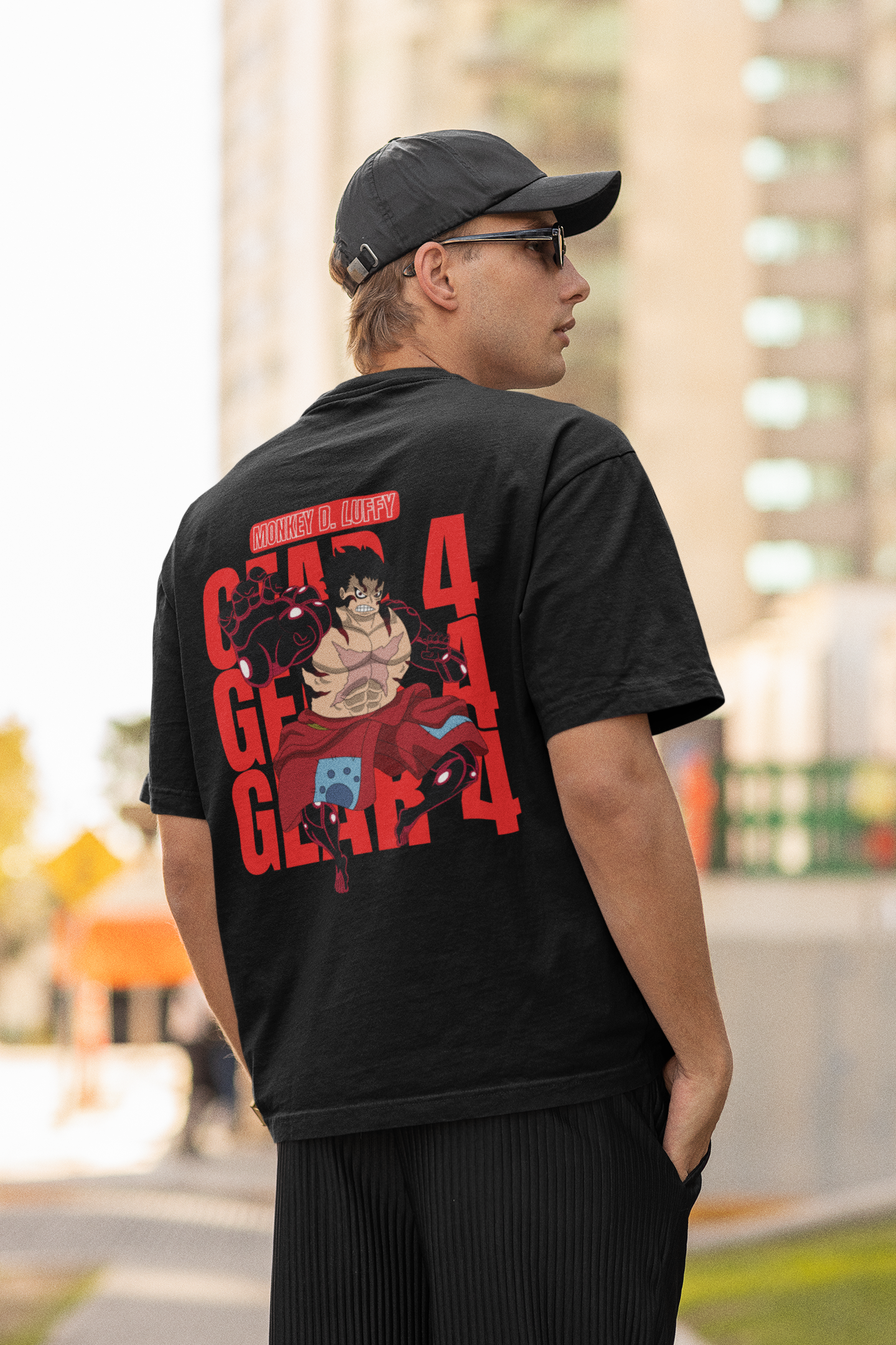 Back view of a male model wearing a black oversized t-shirt featuring Luffy in his Gear 4 Bounceman form from the One Piece anime.