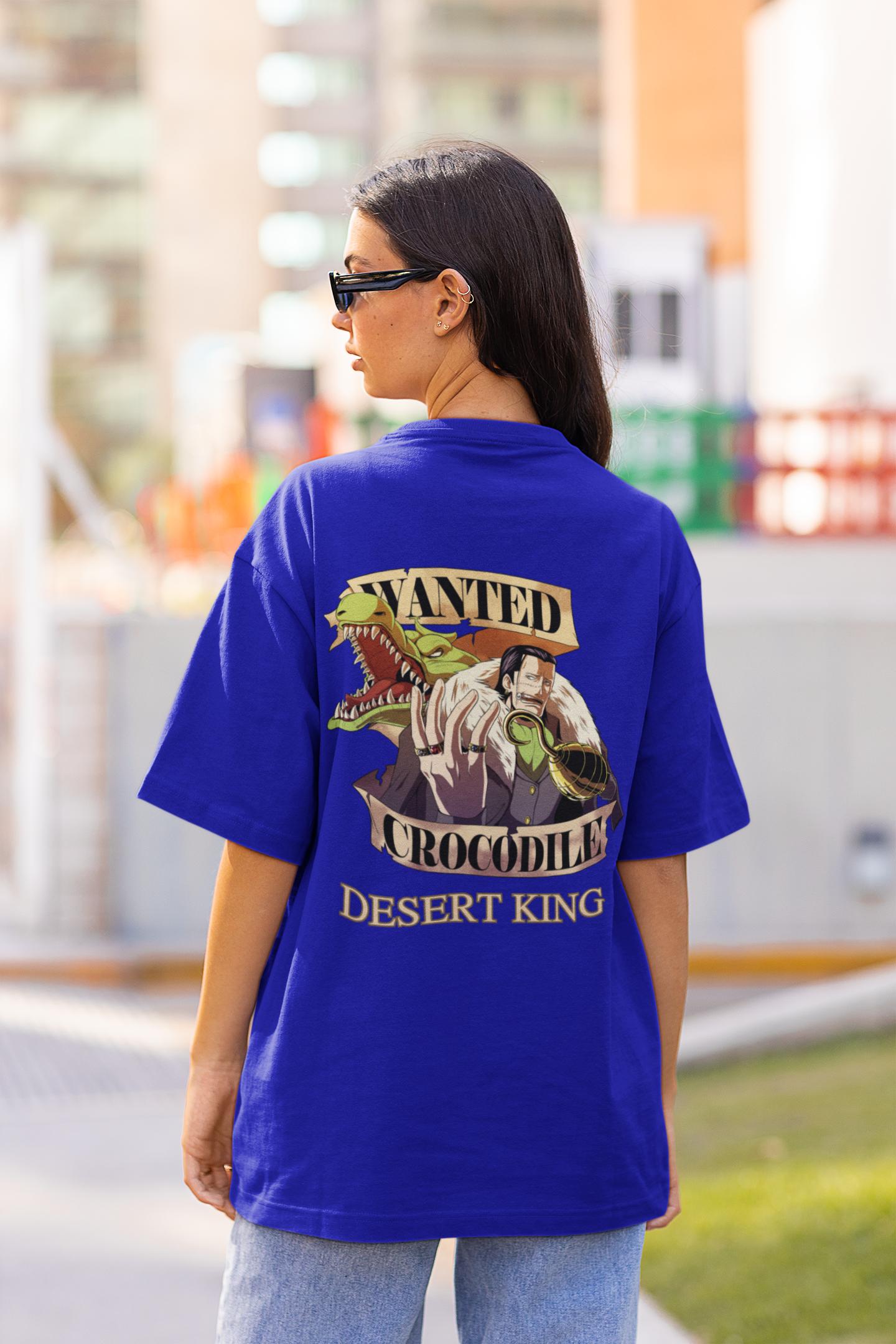 Back view of a female model wearing a royal blue oversized t-shirt featuring Crocodile, the Desiccation Master, from the One Piece anime.