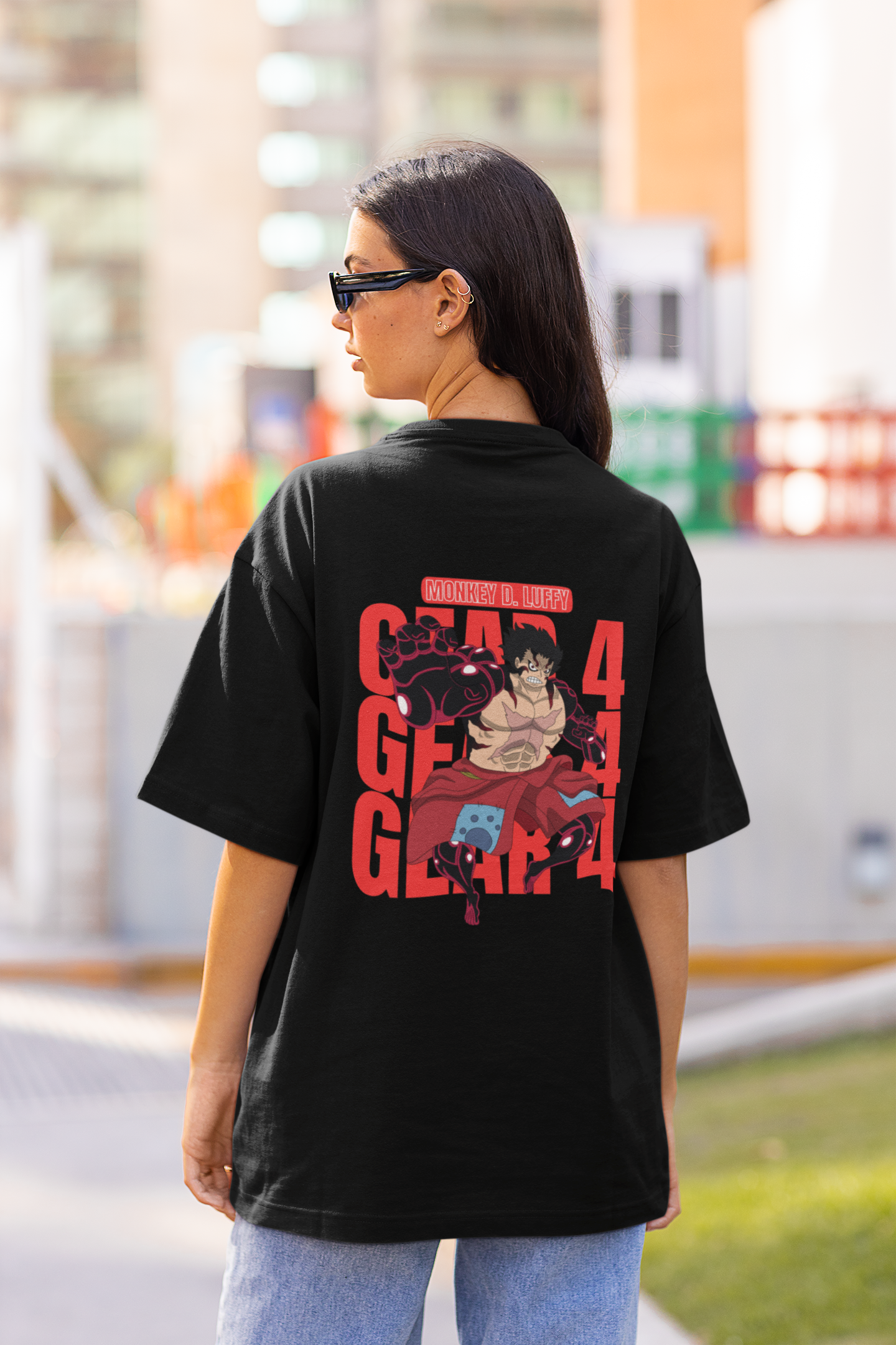 Back view of a female model wearing a black oversized t-shirt featuring Luffy in his Gear 4 Bounceman form from the One Piece anime.