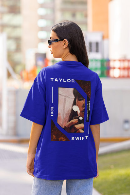 Back view of woman wearing blue coloured Oversize T-shirt featuring Taylor Swift 1989 design, Taylor's Version, and Eras Tour Merch