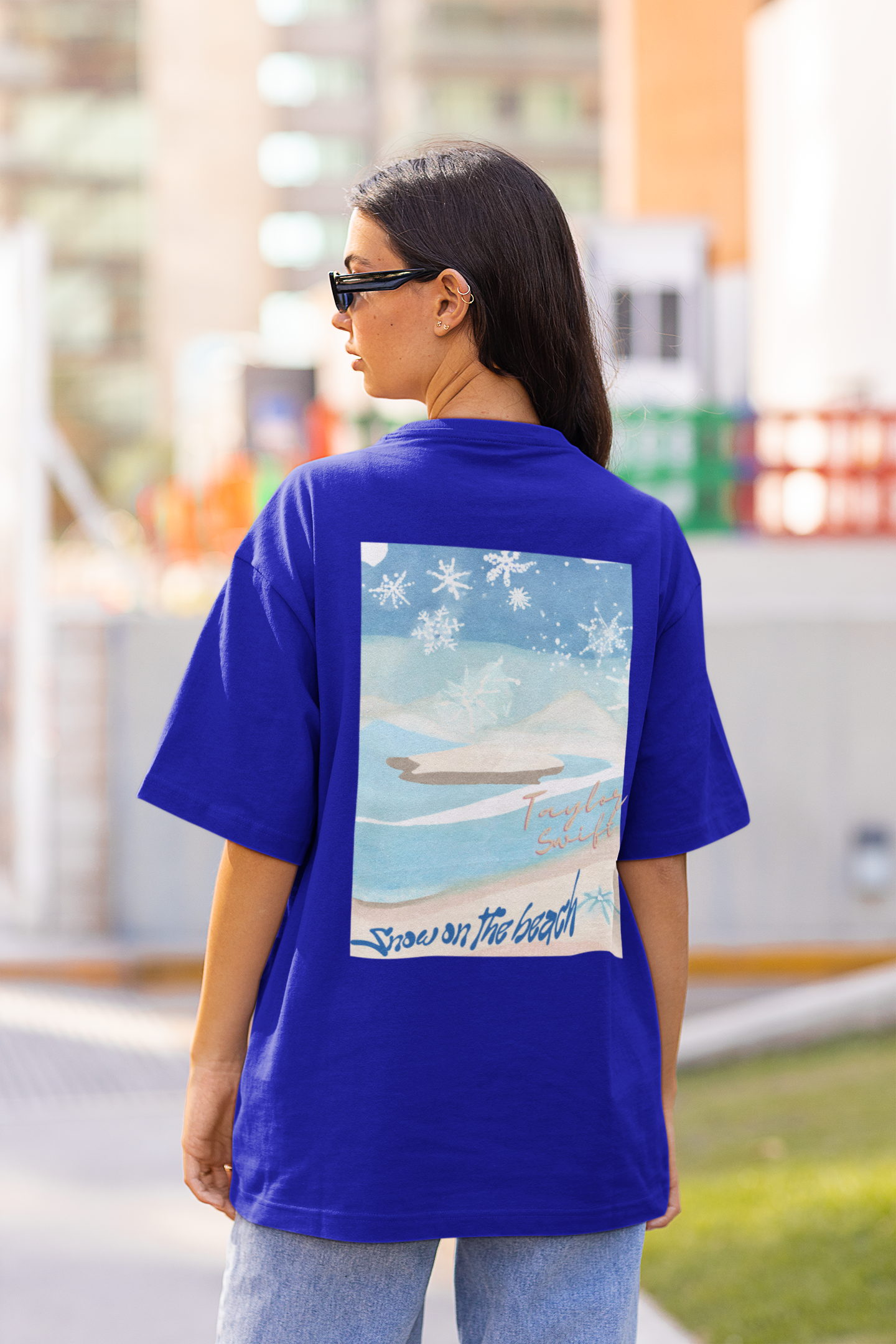 Back view of female model rocking blue oversized tees with Taylor Swift 'Snow on the Beach' design, perfect for capturing the essence of 'Snow on the Beach' and celebrating Taylor's eras, including 'Midnights' and 'Taylor's Version'.