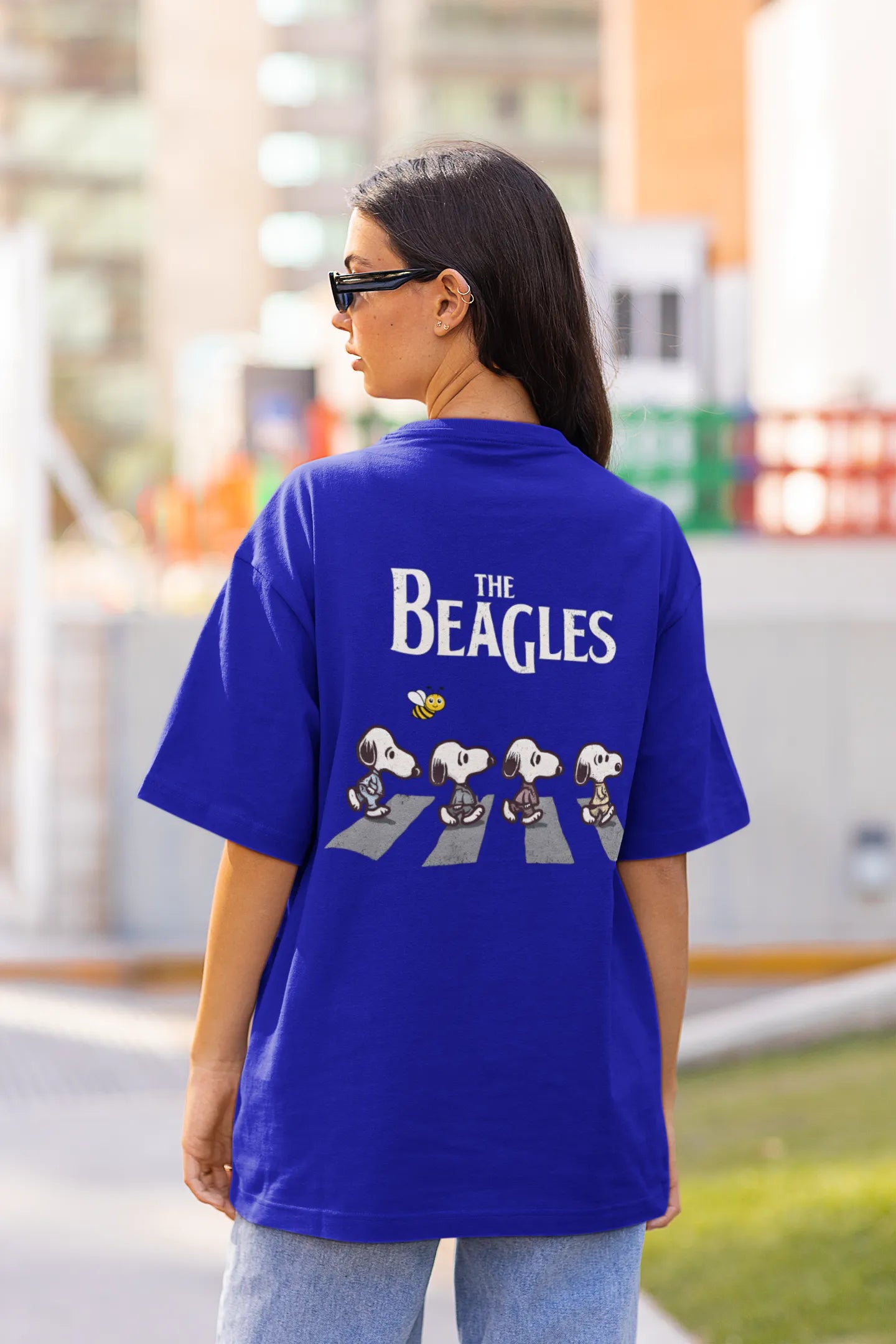 Back view of female Model showcasing blue oversized tee with a The Beagles animated series themed design, featuring the cool canine quartet from ourt disney collection of oversized tees.