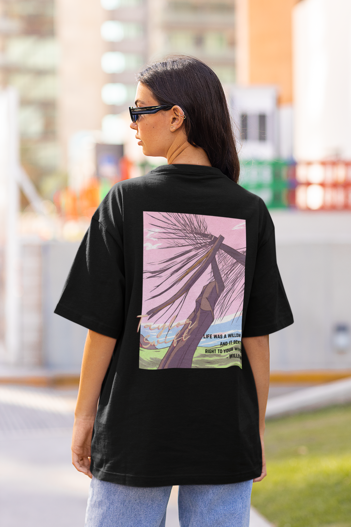Back view of model wearing black oversized Taylor Swift Willow t-shirt featuring designs inspired by her album Evermore (Taylor's Version)