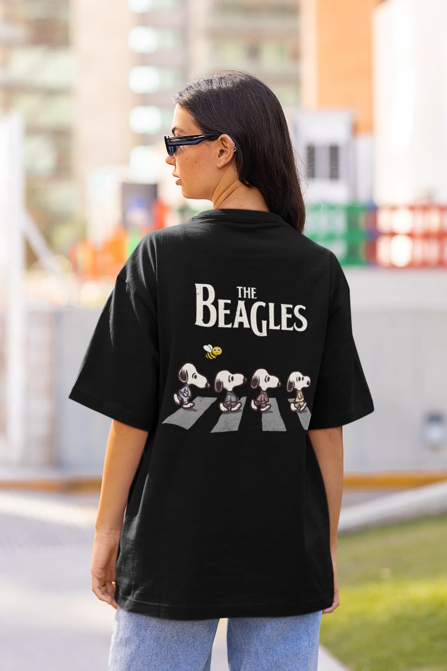 Back view of female Model showcasing black oversized tee with a The Beagles animated series themed design, featuring the cool canine quartet from ourt disney collection of oversized tees.