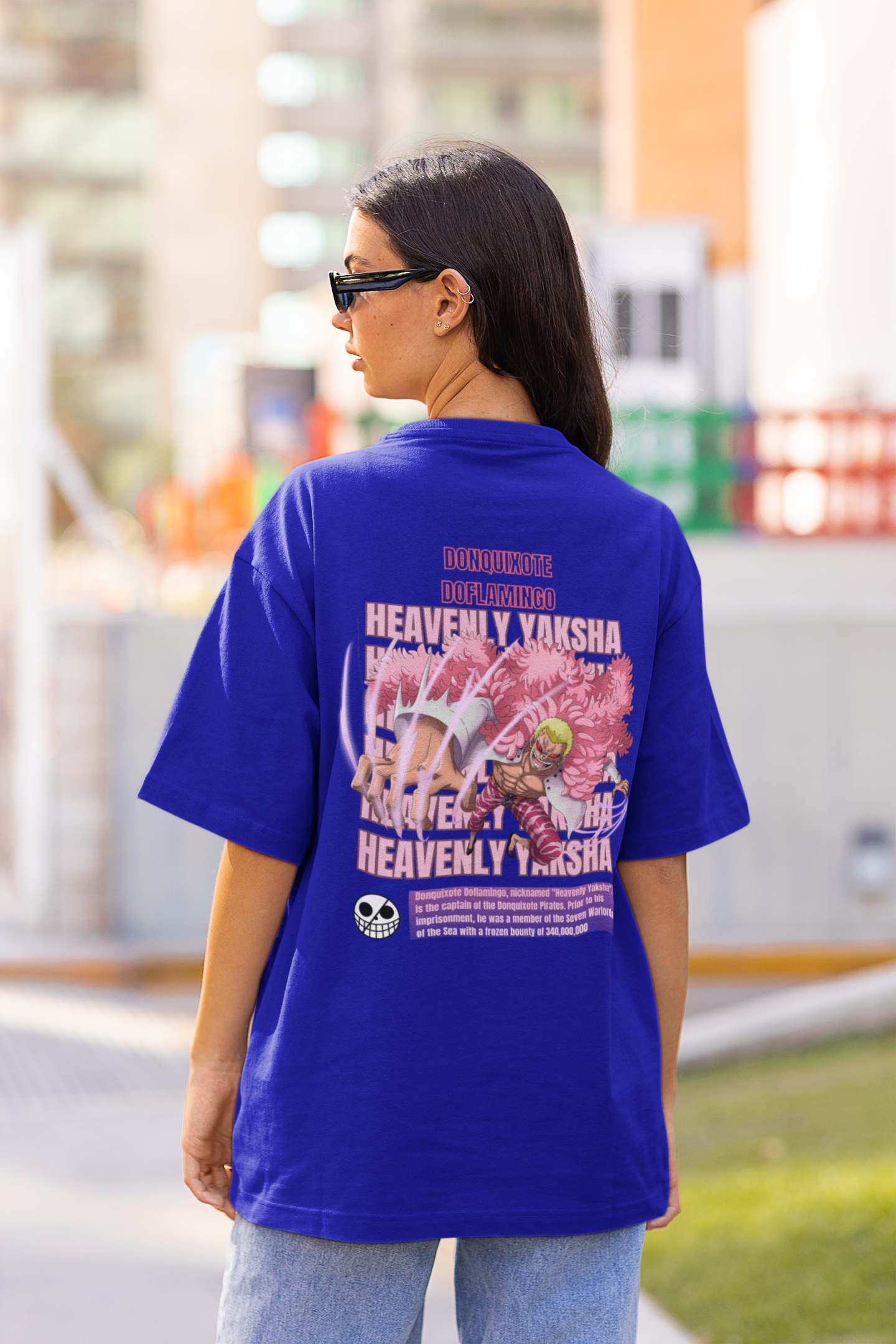Back view of a female model wearing a royal blue oversized t-shirt featuring Donquixote Doflamingo from the One Piece anime.