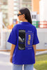 Back view of female model wearing a royal blue oversized t-shirt featuring a captivating 