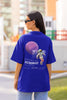 Back view of female model wearing a blue oversized t-shirt featuring a design inspired by the cosmos and galaxies 