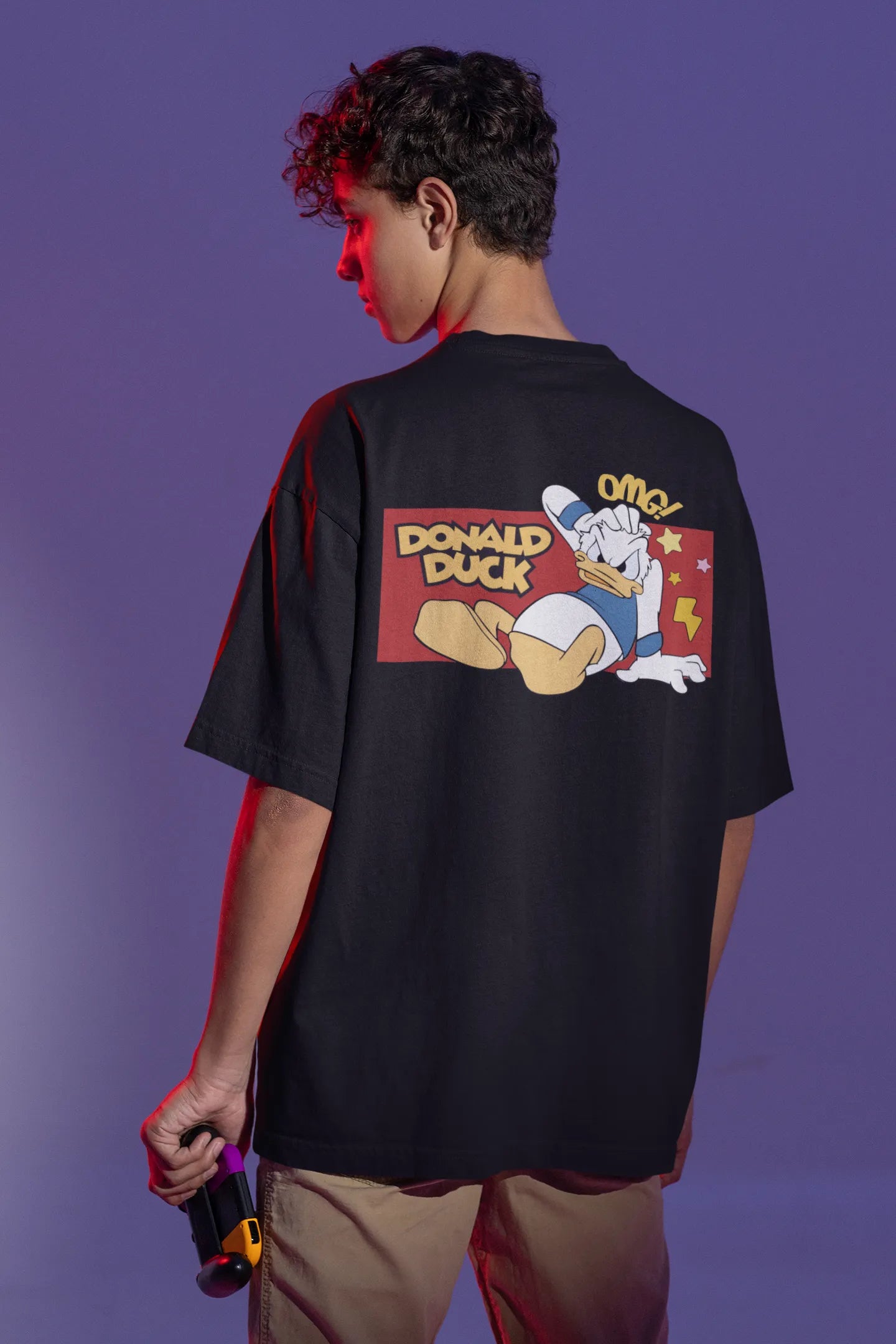 Back view of male model wearing black oversized Disney collection t-shirt featuring a classic Donald Duck design.