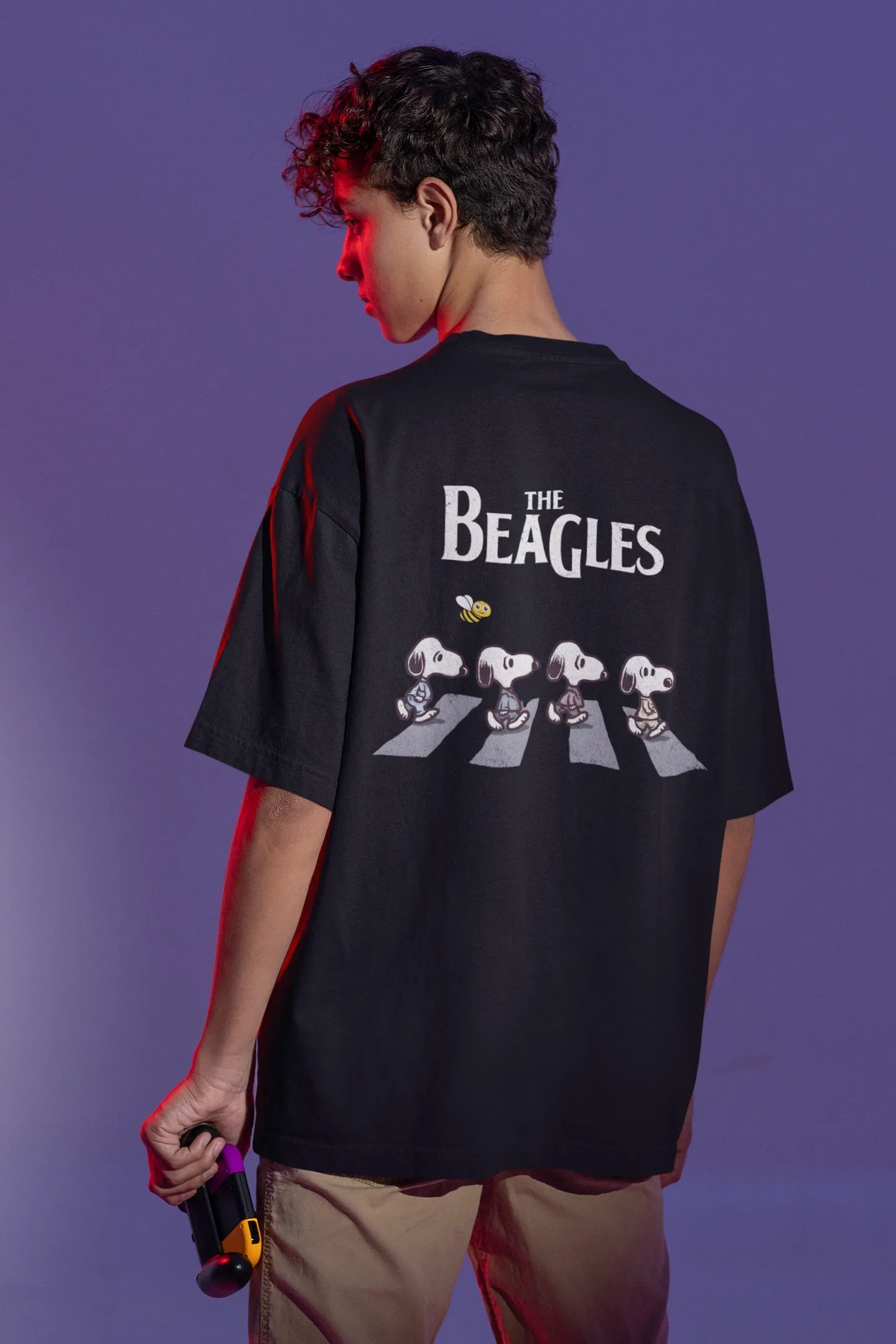 Back view of male Model showcasing black oversized tee with a The Beagles animated series themed design, featuring the cool canine quartet from ourt disney collection of oversized tees.