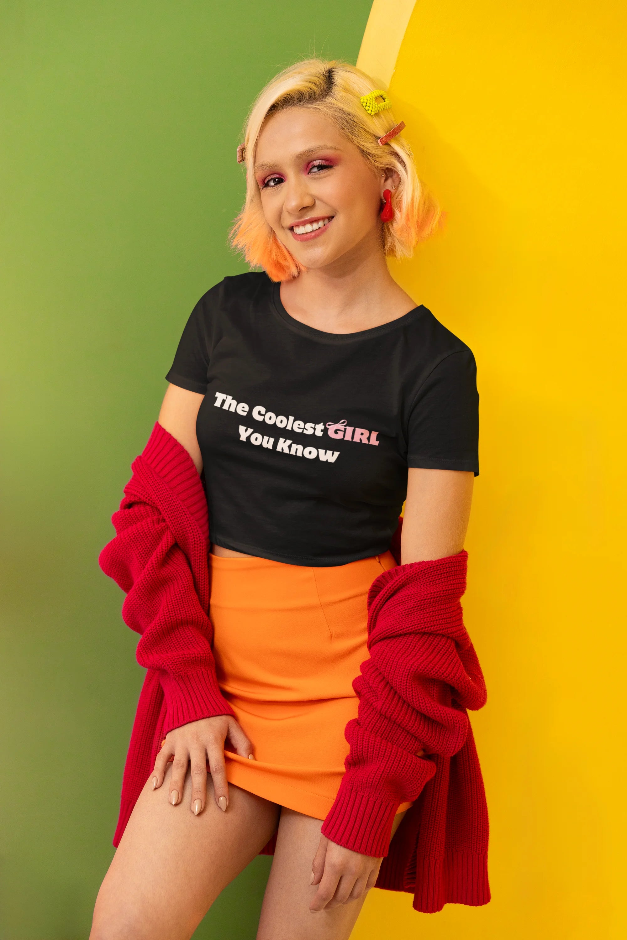 Side view of female model wearing a black crop top with "coolest girl you know" text, exuding confidence and style.