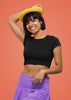 First front view of model wearing a stylish black crop top, exuding confidence and attitude.