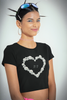 Side view of a female model wearing a stylish black crop top with an 11:11 pearl heart design, exuding angelic confidence and attitude.from our shaw-tee collection