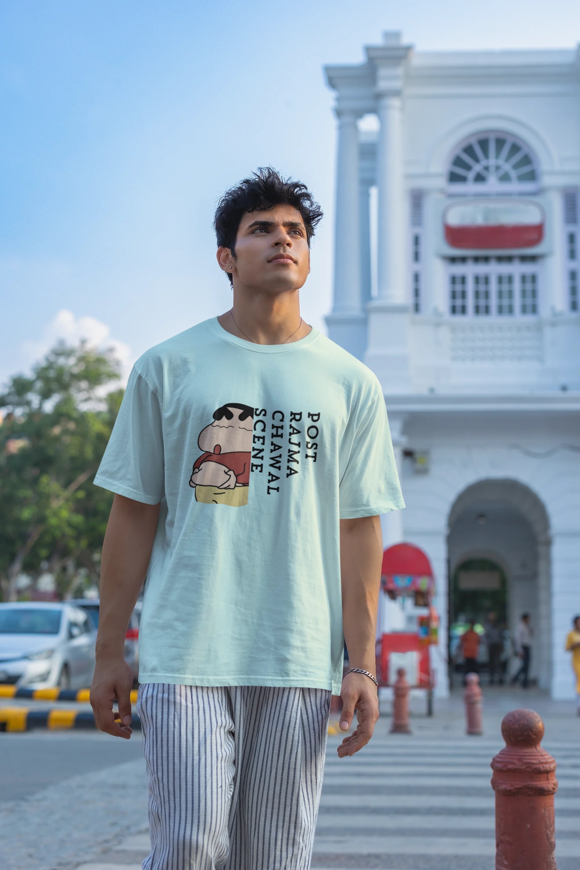 Third front image of male model wearing an oversized mint green tee with a humorous design of Shinchan enjoying a food coma. A must-have for Shinchan fans and food lovers.