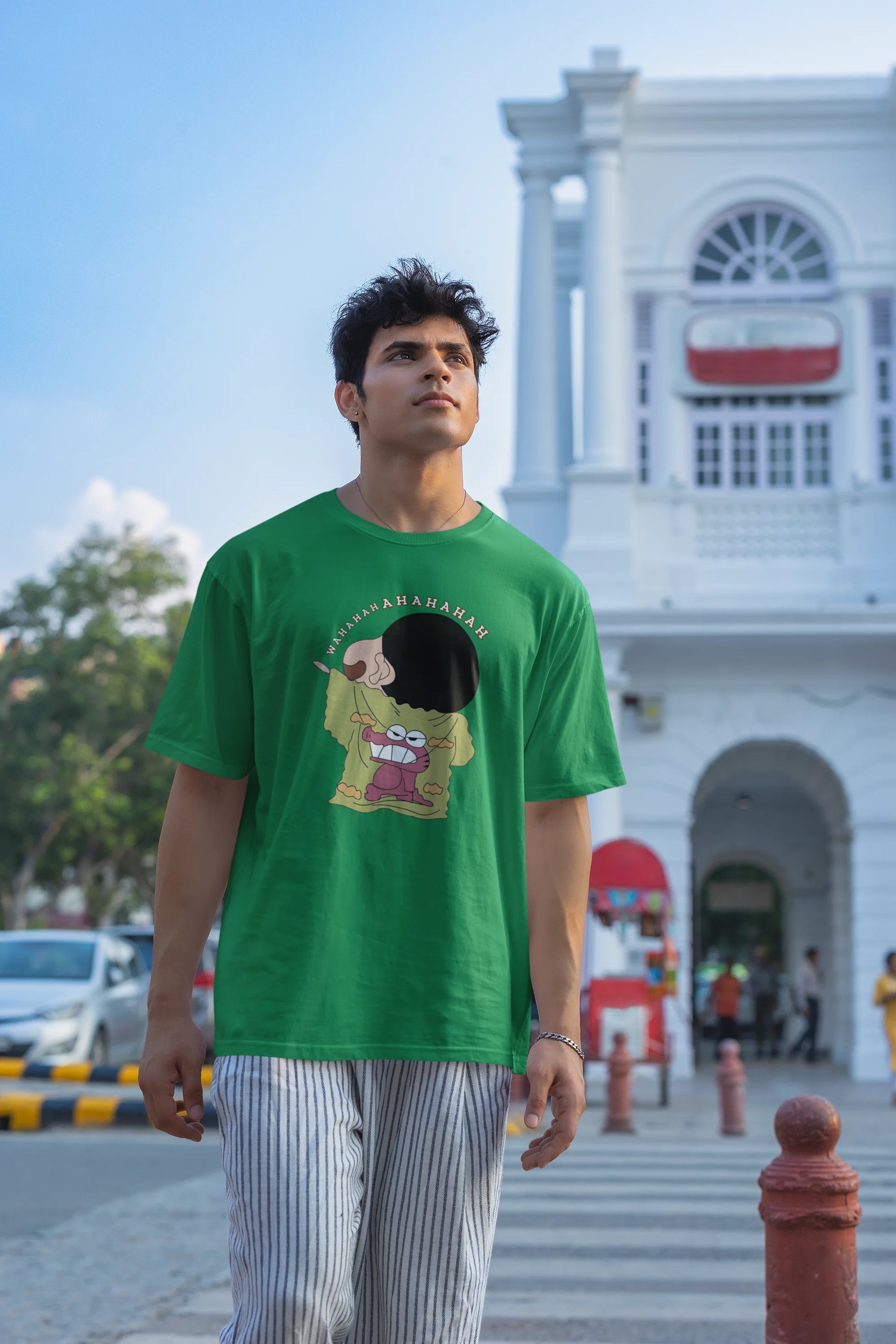 Second front view of male model wearing a forest green oversized t-shirt with a design of Shinchan laughing hysterically. Perfect for Shinchan fans who love the character's humor.