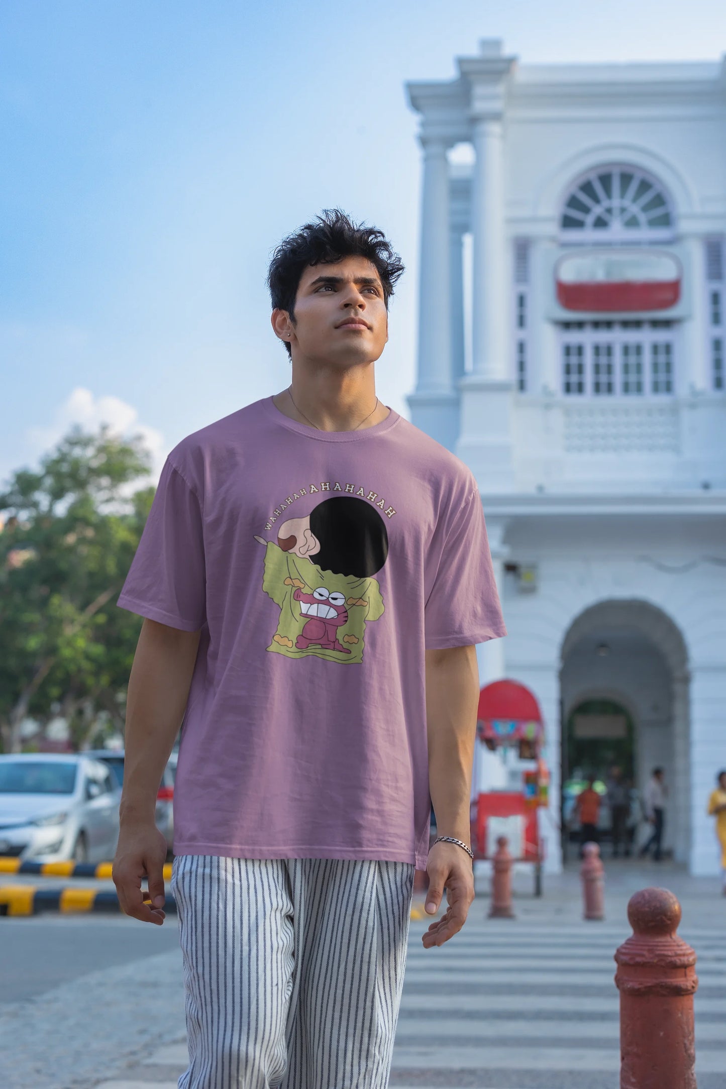 Second front view of male model wearing a dirty purple oversized t-shirt with a design of Shinchan laughing hysterically. Perfect for Shinchan fans who love the character's humor.