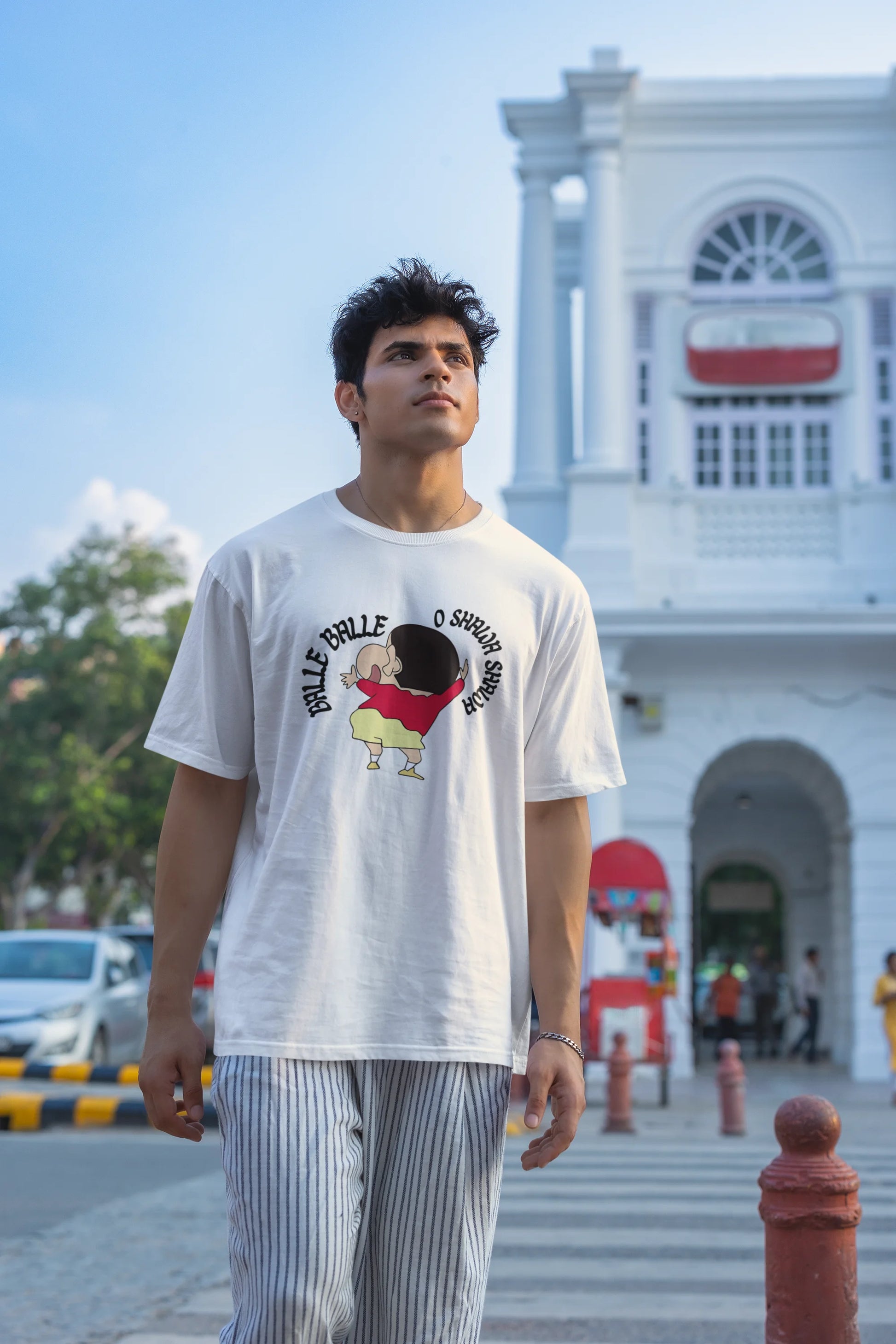 Second front view of male model wearing an oversized off-white tee with Shinchan dancing and the text "Balle Balle". A perfect blend of anime and Bollywood for Shinchan fans.