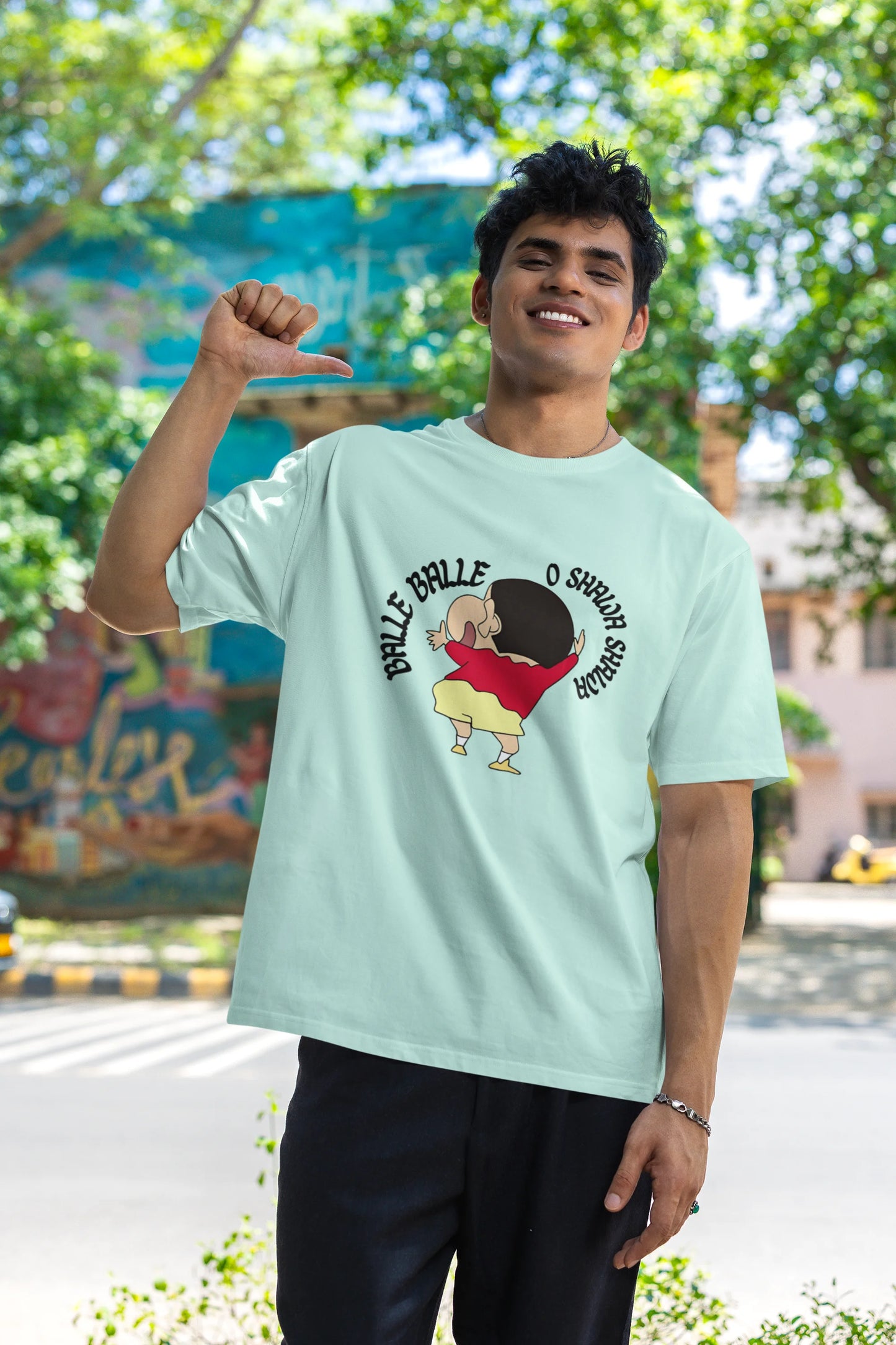 Second front view of male model wearing an oversized mint green tee with Shinchan dancing and the text "Balle Balle". A perfect blend of anime and Bollywood for Shinchan fans.