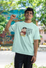 First front image of male model wearing an oversized mint green tee with a humorous design of Shinchan enjoying a food coma. A must-have for Shinchan fans and food lovers.