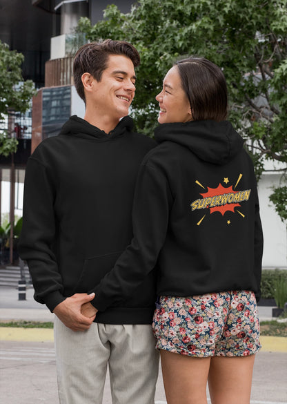Front and back view of a couple wearing matching black hoodies, one with the word "Superhero" and the other with the word "Superwoman" in a flashy font.