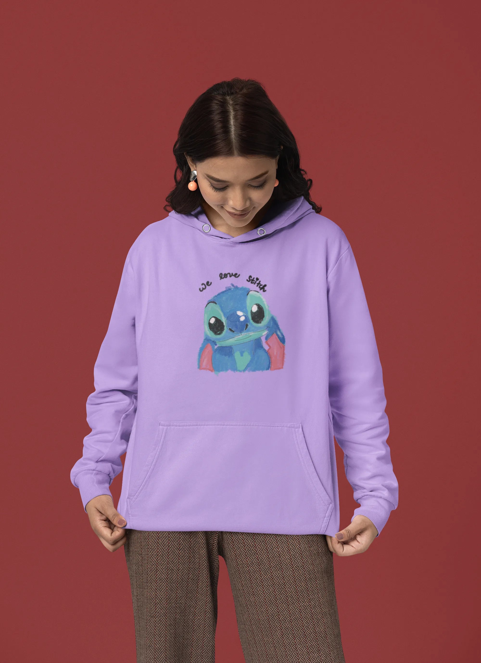 Fourth front view of a female model wearing a lavender hoodie with a large Stitch design. The illustration shows Stitch smiling and waving.