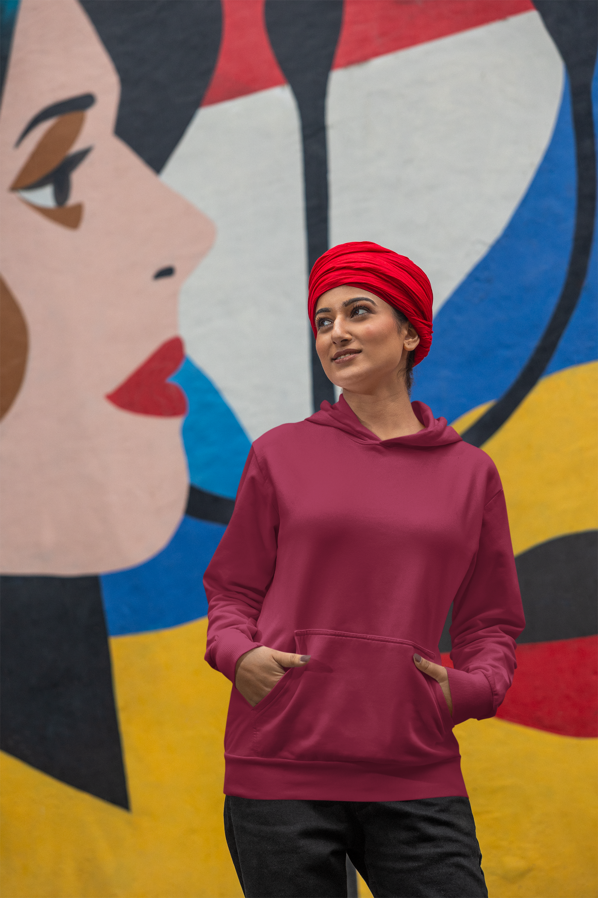 First front view of a female model wearing a maroon hoodie with a portrait of Diljit Dosanjh and lyrics from the song "Ikk Kudi."