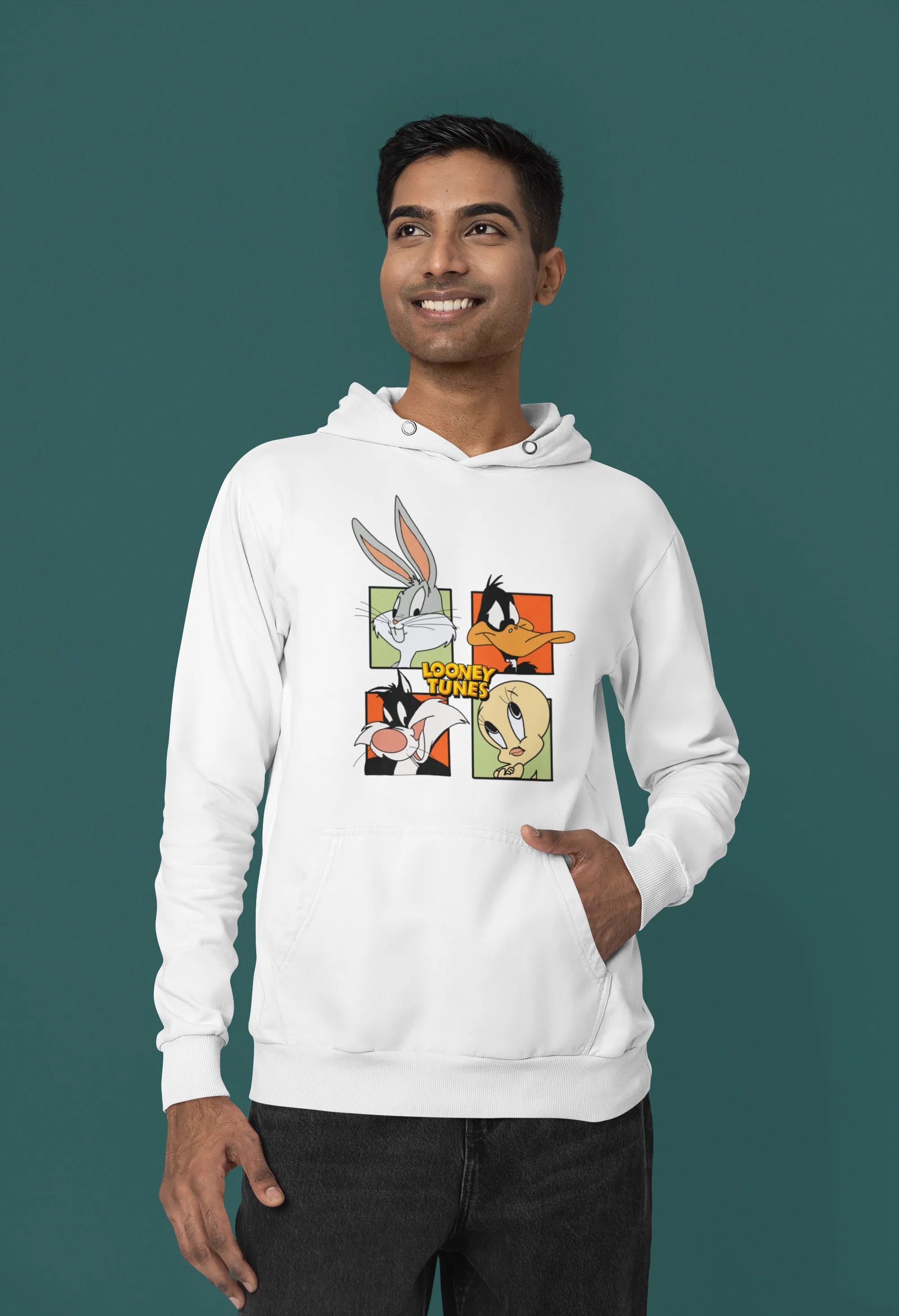 Second image of a male model wearing a white hoodie with a large Looney Tunes design. The illustration features portraits of several iconic Looney Tunes characters.