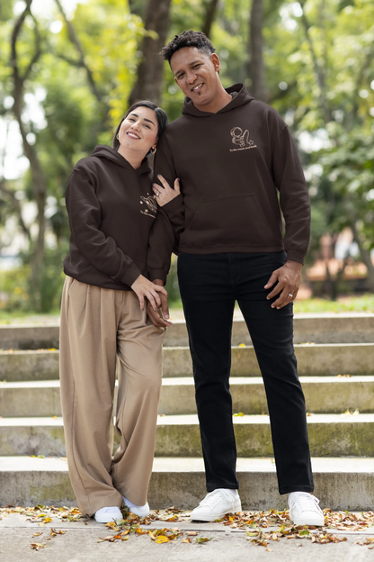 First front view of a couple wearing matching chocolate brown hoodies, one with an astronaut design and the other with a planet design, along with the text "To the Moon and Back."
