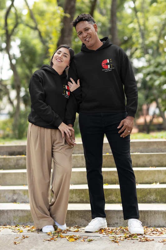 2nd front view of a couple wearing matching hoodies with a design of two animated magnets attracting each other, and the text "Cute Things Attract".