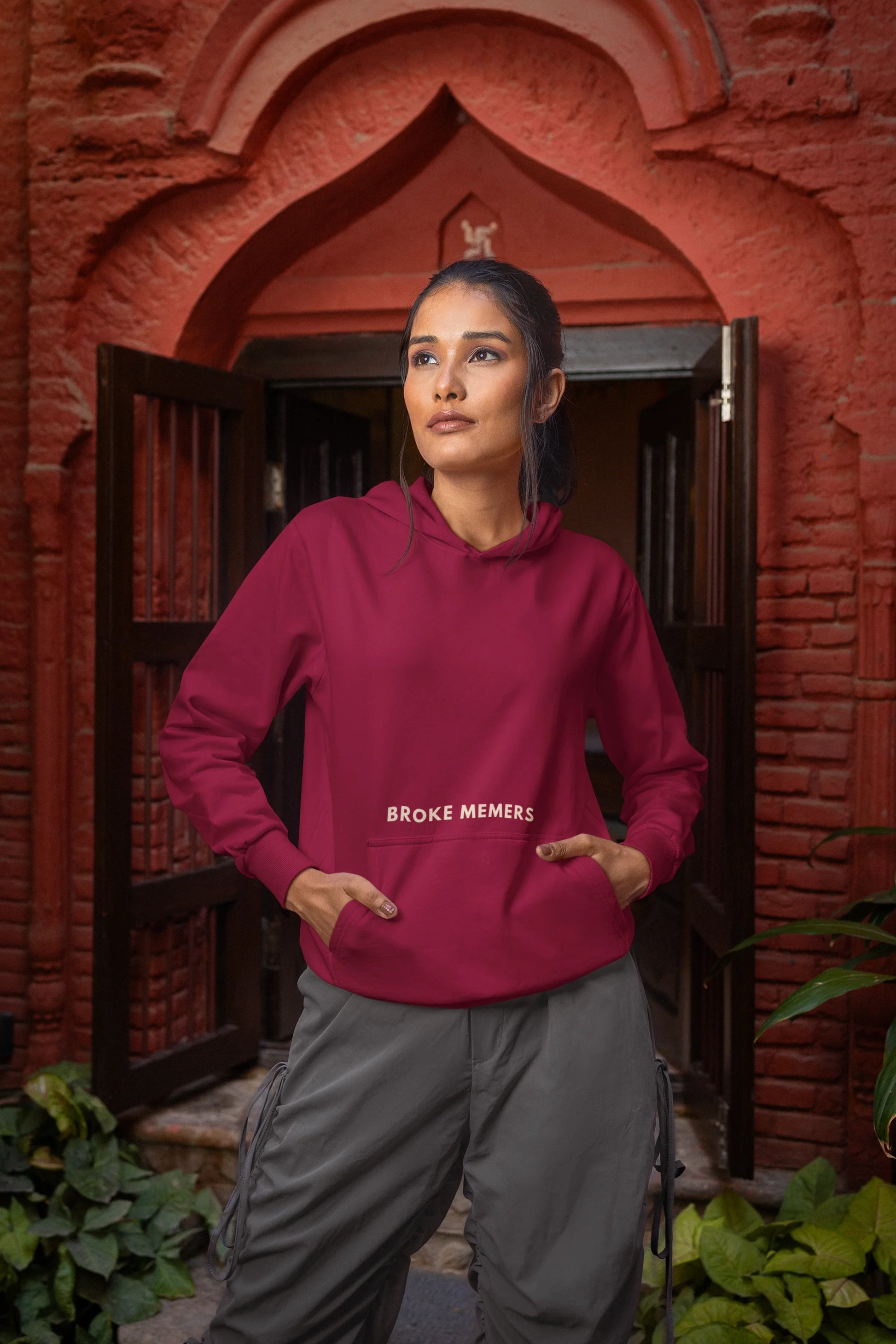 Front view of a female model wearing a maroon hoodie with a Disney design featuring a muscular duck and the text "The Honk."