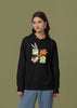 Second image of a female model wearing a black hoodie with a large Looney Tunes design. The illustration features portraits of several iconic Looney Tunes characters.