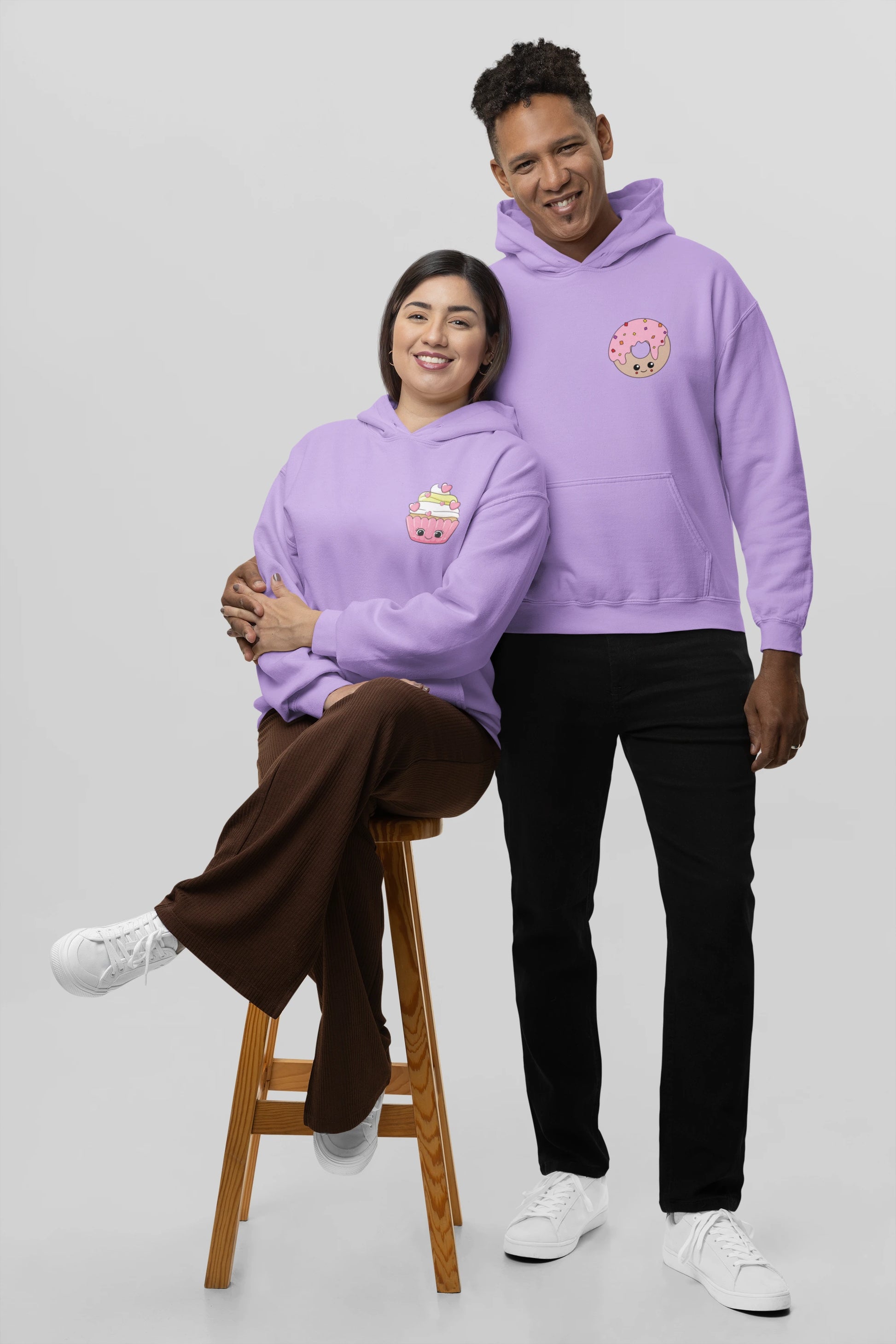 2nd front view of a couple wearing matching lavender hoodies, one with a animated donut and the other with a cupcake.