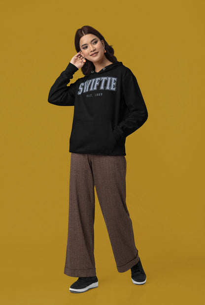 Side view of a female Model wearing an black Swiftie hoodie, perfect for Taylor Swift fans and Eras Tour enthusiasts.
