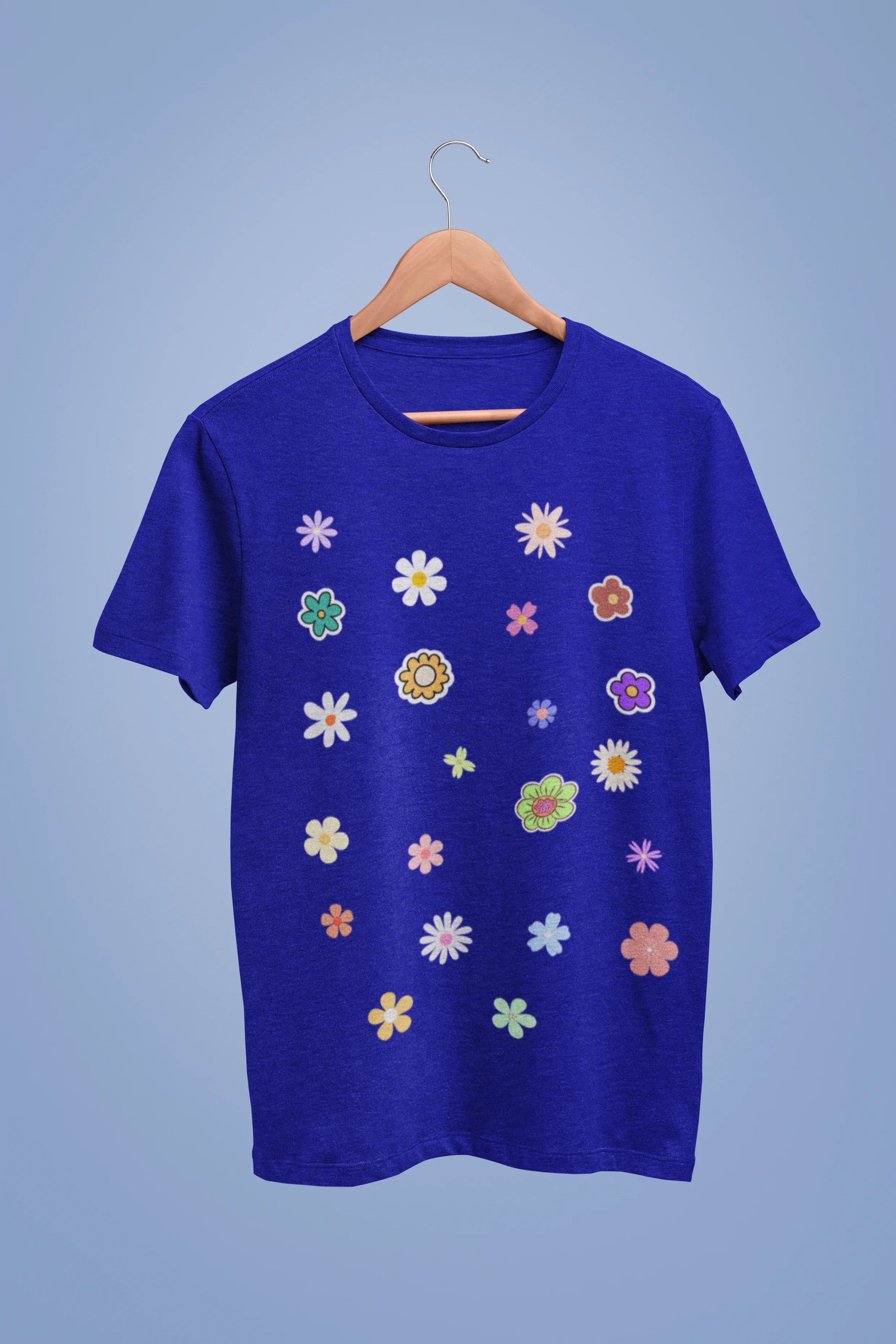 A royal blue oversized t-shirt featuring a vibrant floral design with roses, tulips, sunflowers, and orchids. Ideal for those who love floral patterns and spring fashion. 