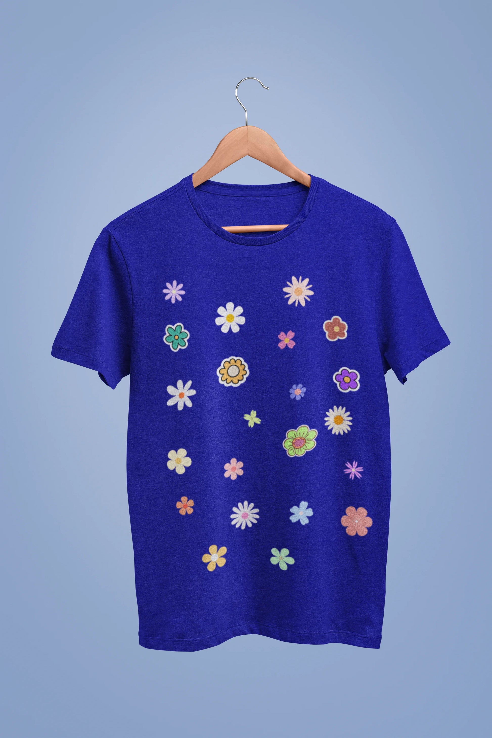 A royal blue oversized t-shirt featuring a vibrant floral design with roses, tulips, sunflowers, and orchids. Ideal for those who love floral patterns and spring fashion.