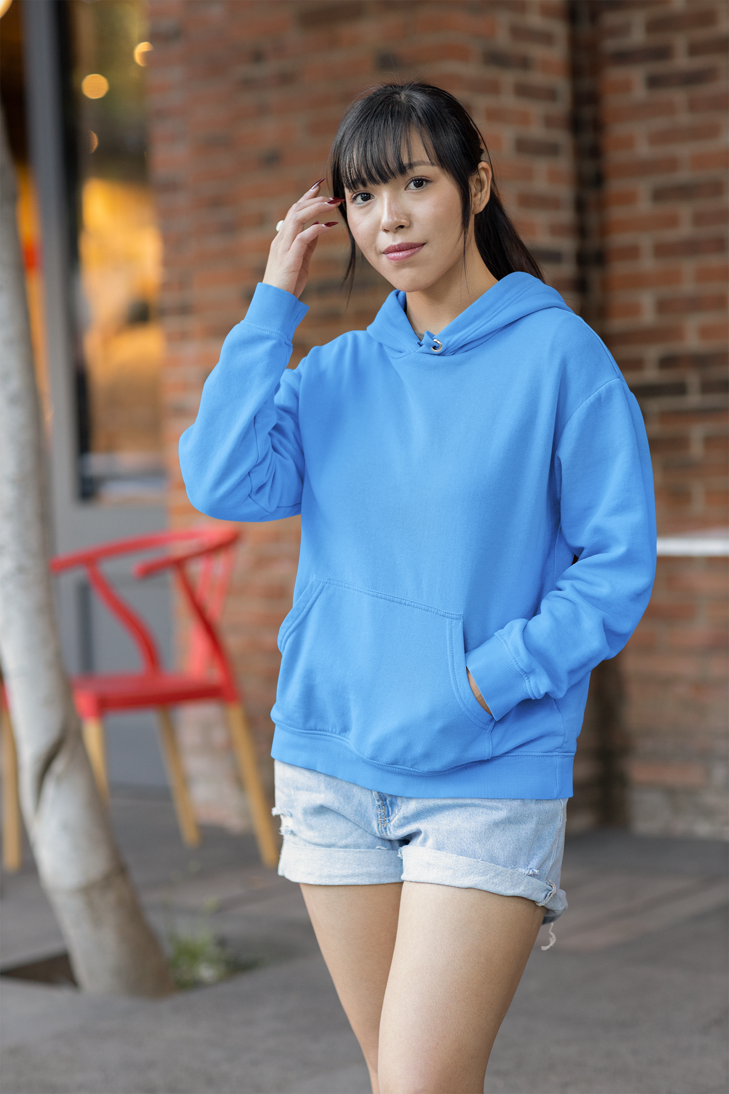Front view of a female model wearing a sky blue premium quality, pure cotton hoodie.