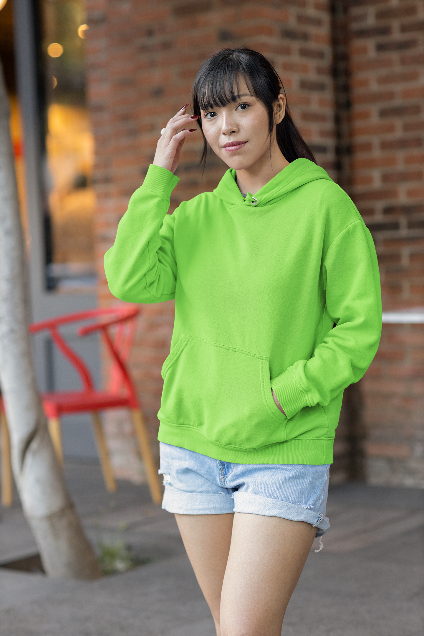 Front view of a female model wearing a parrot green premium quality, pure cotton hoodie.