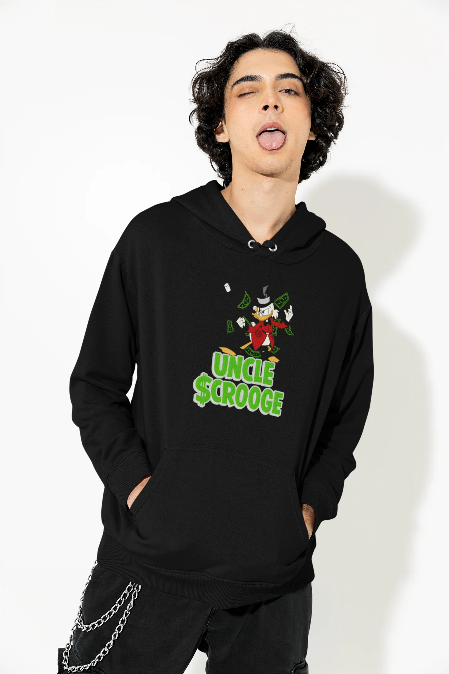 Front view of a male model wearing a black hoodie with a Disney Uncle Scrooge design, showing dollar bills raining down on him.