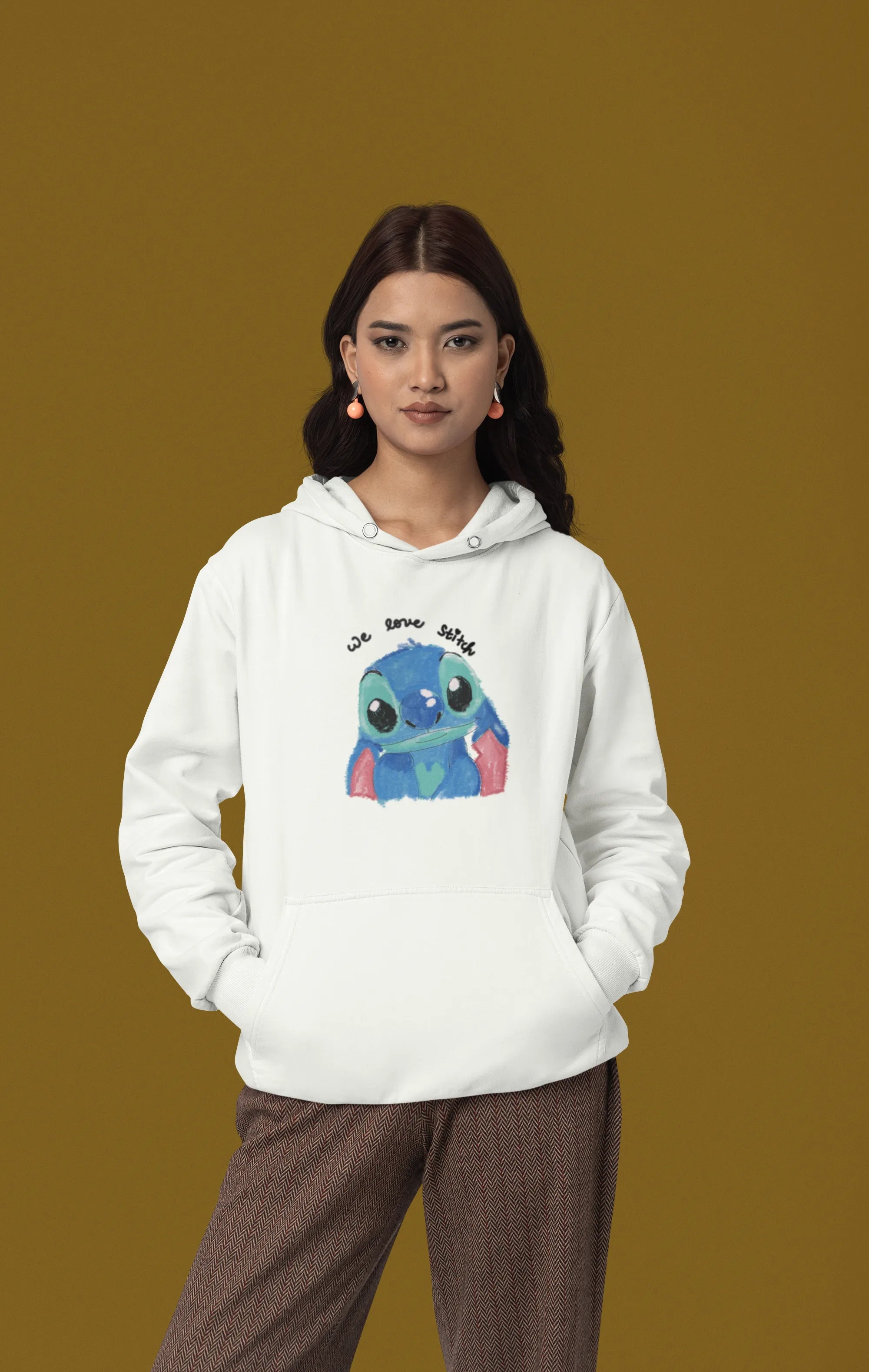 First front view of a female model wearing a white hoodie with a large Stitch design. The illustration shows Stitch smiling and waving.