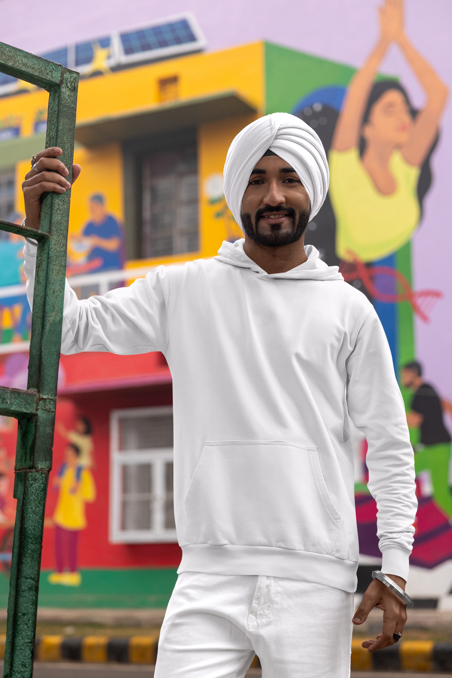 First front view of a male model wearing a comfortable white hoodie featuring the phrase "Vibe Teri Meri" in a modern font on a portrait of Diljit Singh holding up a sunflower, perfect for expressing your unique style and feeling the rhythm.