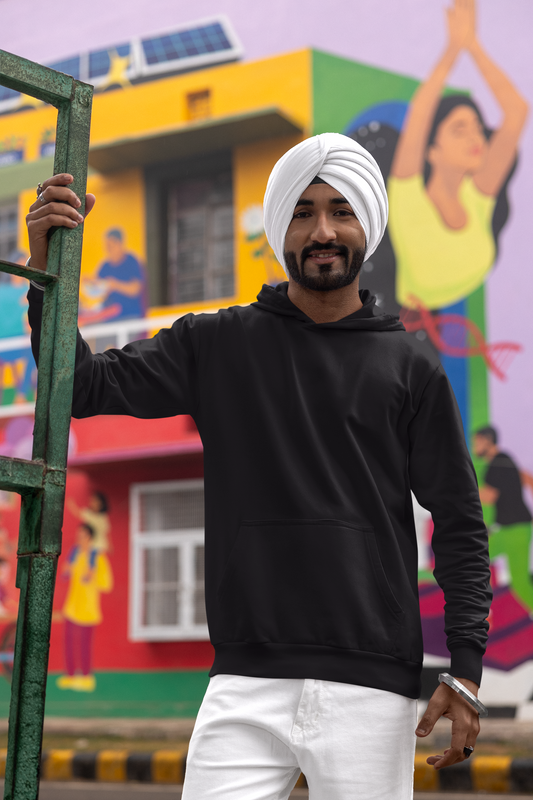 Front view of a male model wearing a black hoodie with a portrait of Diljit Dosanjh and lyrics from the song "Ikk Kudi."