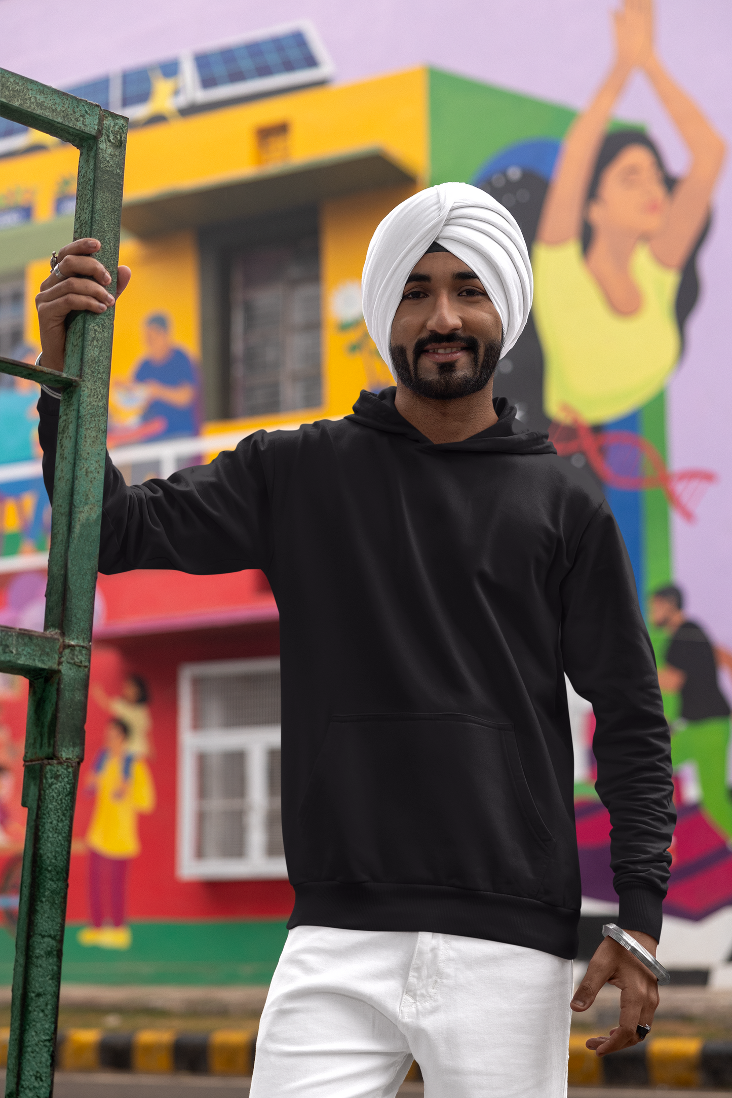 First front view of a male model wearing a black hoodie with Diljit holding up a sunflower with the text "Dil Jeet" in the background.