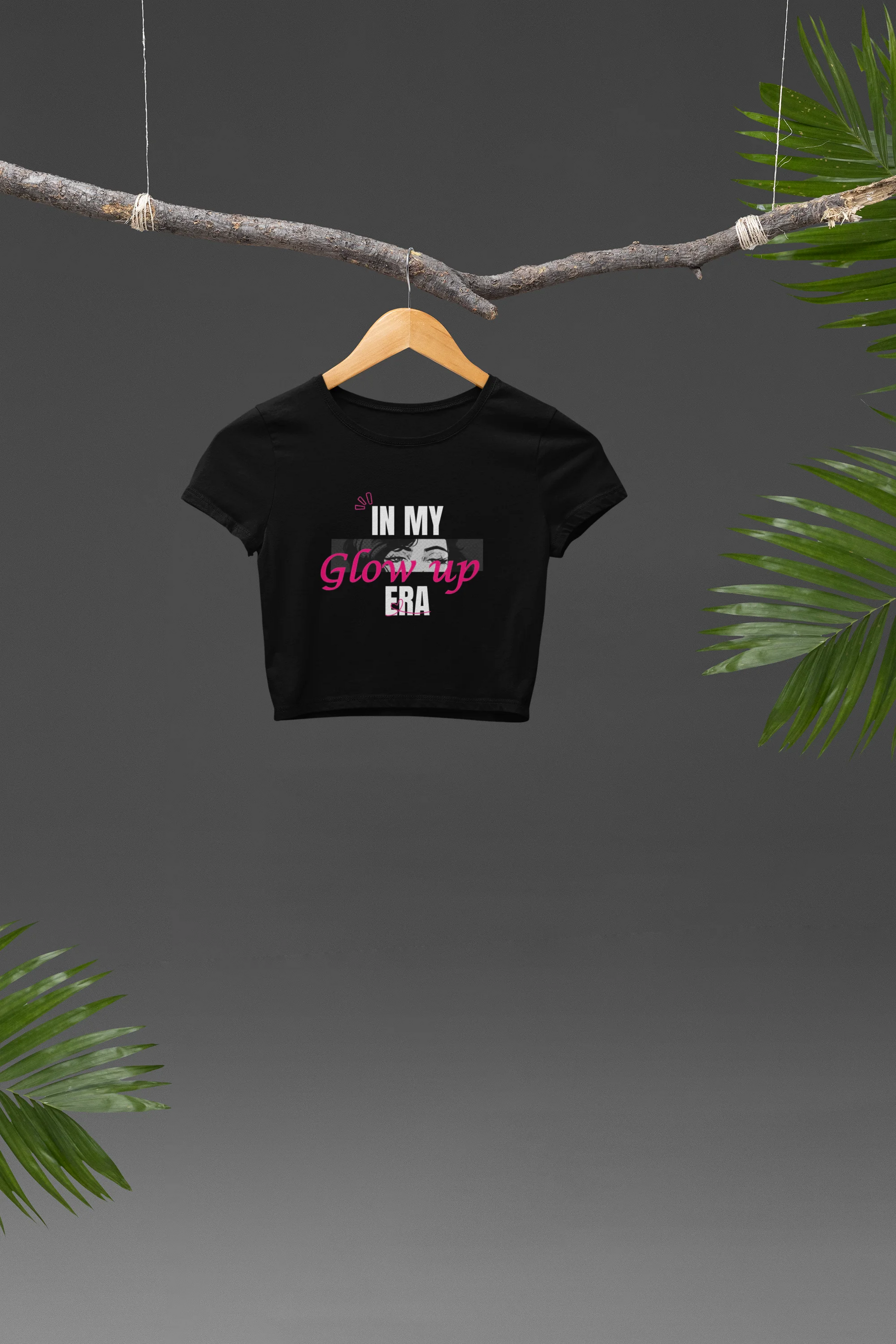 Front view of a black crop top with a floral "in my glow up era" design, exuding confidence and positivity.