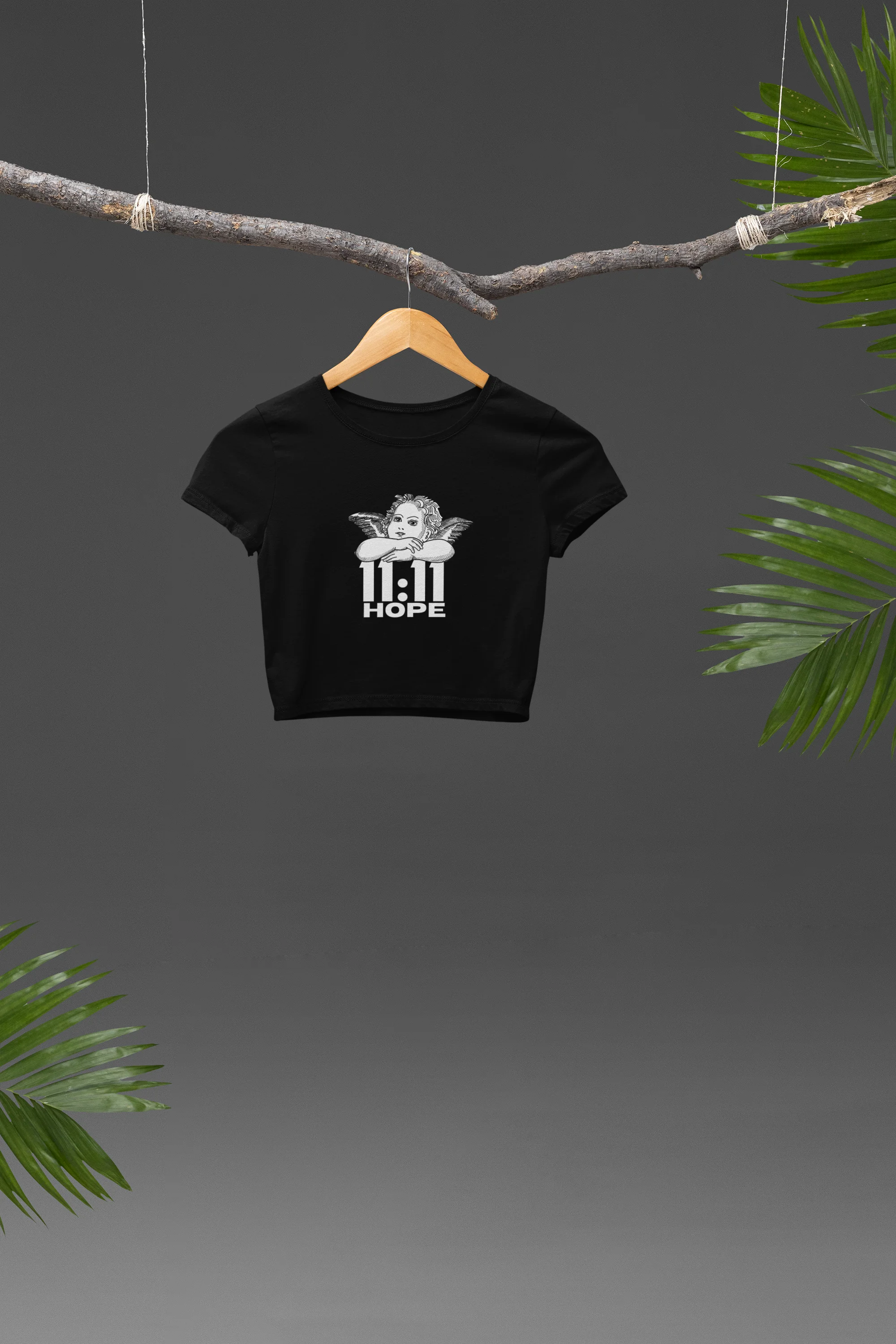 Front view of a black crop top with a baby angel design and "11:11 Hope" text, radiating positivity and hope.