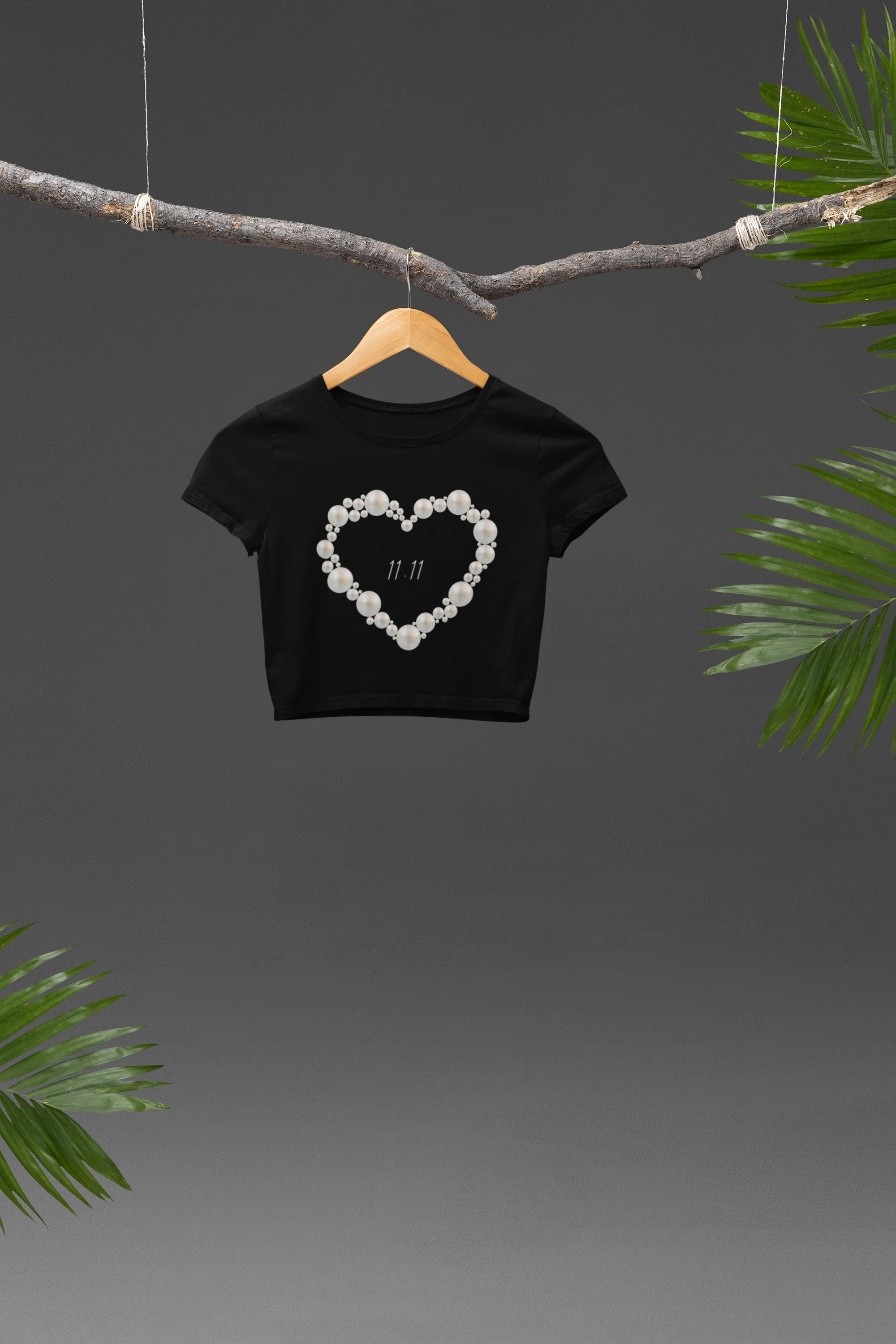 Front view of a stylish black crop top with an 11:11 pearl heart design, exuding angelic confidence and attitude.from our shaw-tee collection